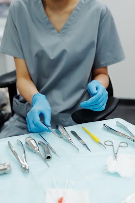 Dental professional in scrubs organizing dental tools on a table.